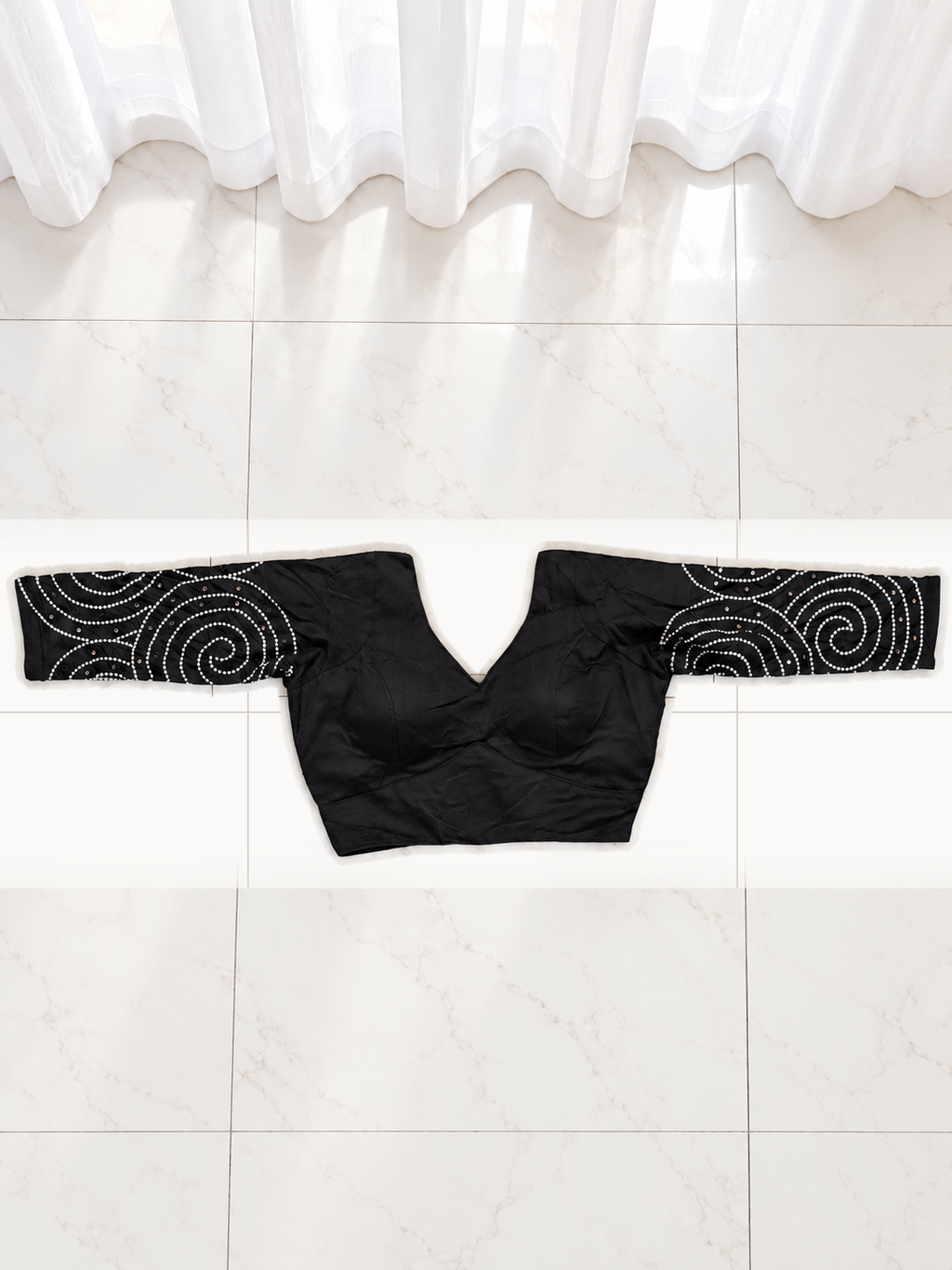 Upright back view of black spiral mirror work blouse