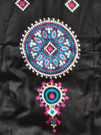 Turquoise pink and white embroidered medallion close-up