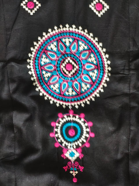 Turquoise pink and white embroidered medallion close-up