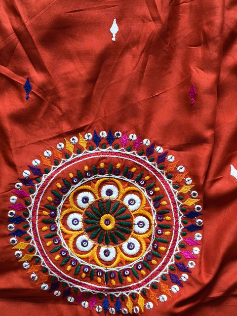 Circular embroidered mirror-work motif close-up